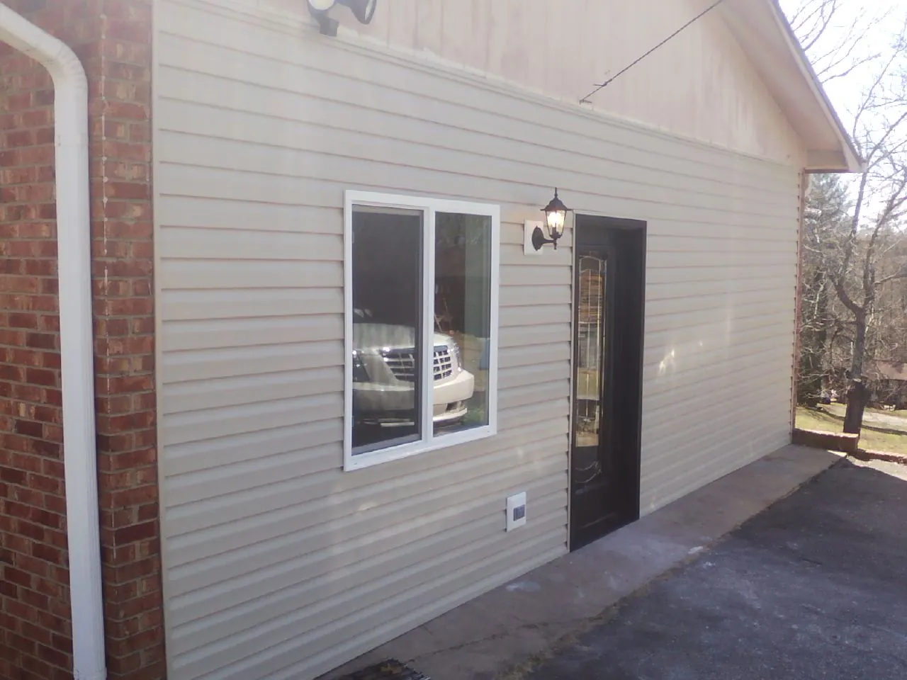 New vinyl siding and entry door on a room addition in Loa