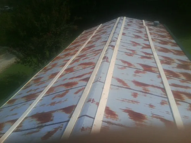 Rusted metal roof panels with new wood purlins before replacement — Storm Damage Roof Repair in Loa by Roofing Brothers