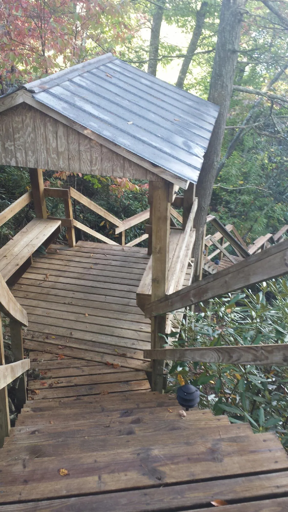 Metal roofed shelter over wooden steps on a wooded walkway — Skylight Repair & Installation work by our crew in Loa