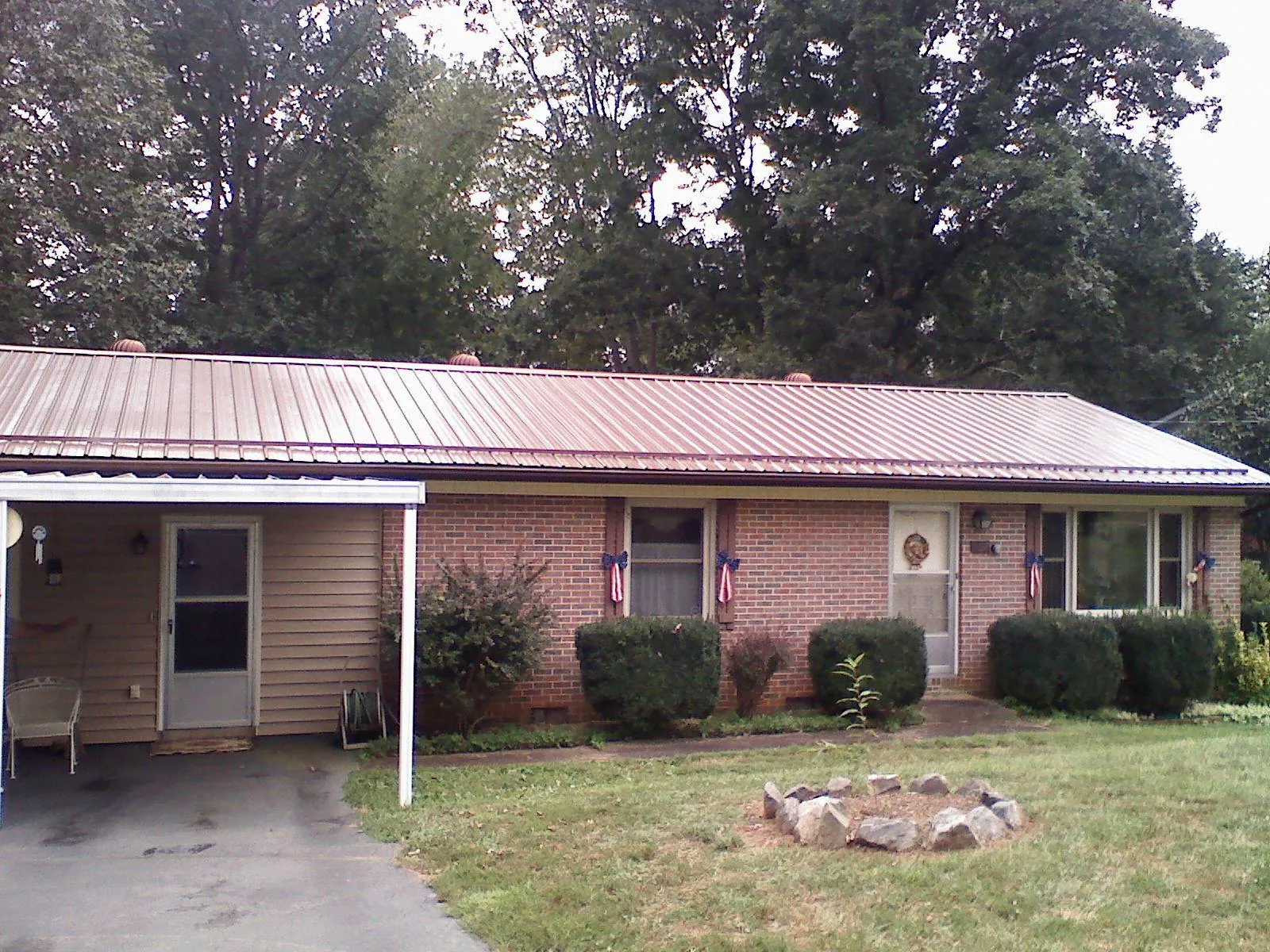 Bronze metal roof and carport on a brick ranch home — Roof Repair work by our crew in Loa